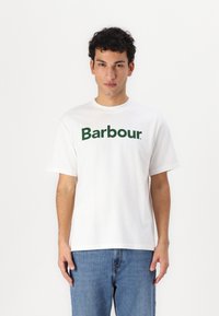 Bílý bavlněný tričko s krátkým rukávem, na kterém je velké zelené logo "Barbour" přes hrudník. Klasický design s kulatým výstřihem.