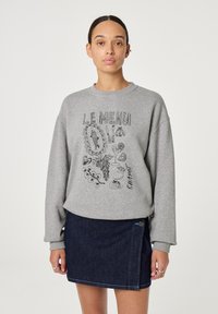 Grijze sweatshirt met grafische tekst "LE MENU" en voedselillustraties, gecombineerd met een donkerdenim rok met een zijrits en blauwe stiksels.