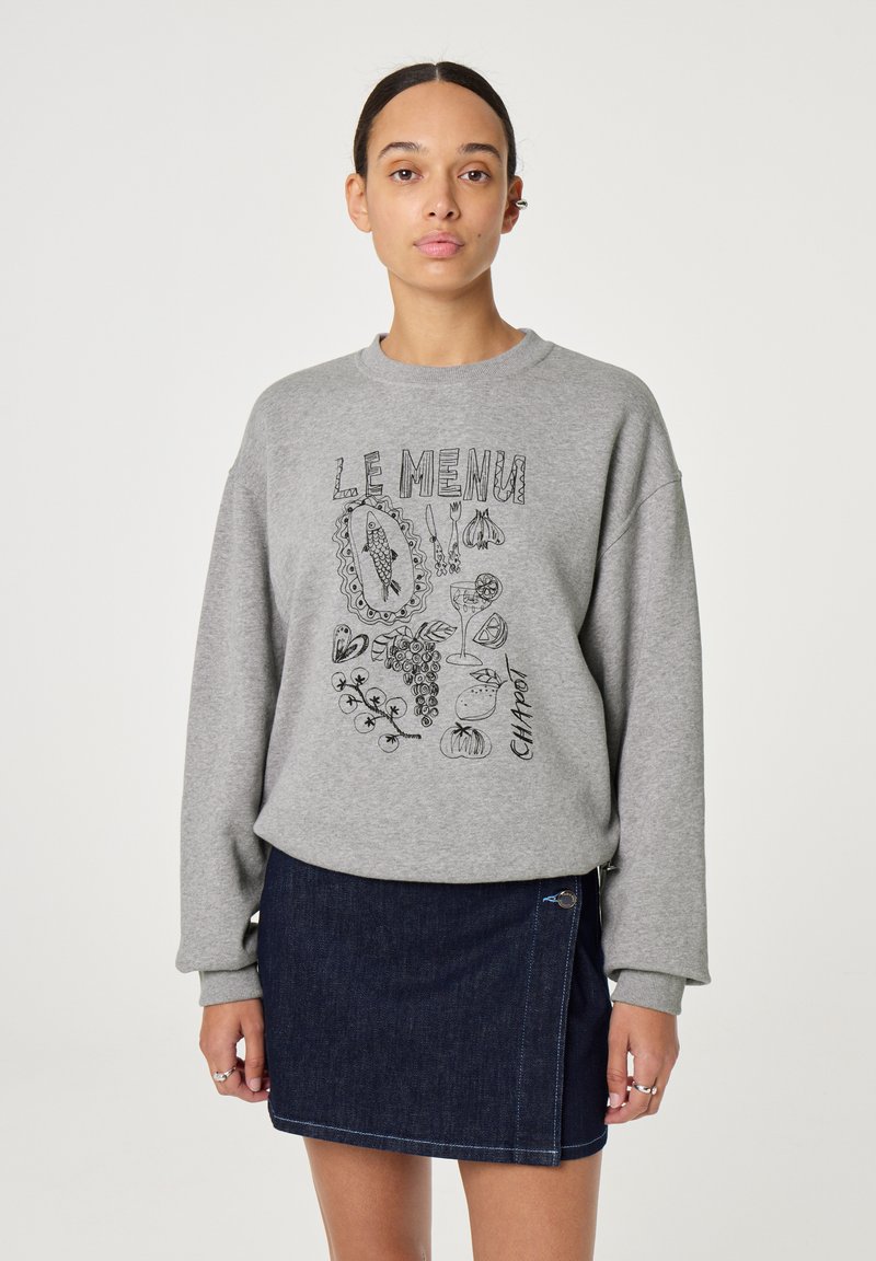Grijze sweatshirt met grafische tekst "LE MENU" en voedselillustraties, gecombineerd met een donkerdenim rok met een zijrits en blauwe stiksels.