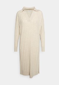 Beige ribbat långklänning med V-ringning och krage, långa ärmar och sidoklyftor för rörelse; tillverkad av mjukt, texturerat tyg.