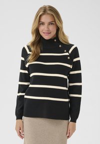 Schwarzer und cremefarbener gestreifter Rollkragenpullover mit goldenen Knopfakzenten und langen Ärmeln. Weiche Textur, lockerer Schnitt mit gerippten Bündchen.