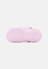 Ροζ παπούτσι τύπου slip-on με λαμπερό επάνω μέρος, υφή στη σόλα με σχέδιο πέλματος και ρ υθμιζόμενο λουράκι για ασφαλή εφαρμογή.