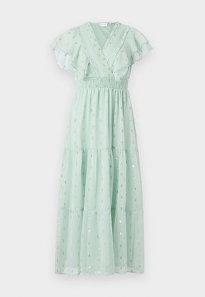 Mėtų žalia suknelė su raukšlėmis rankovėmis, apvyniojimo dizainu ir smulkintu liemeniu. Ypatybės: auksiniai taškų raštai ir sluoksniuota sijono detalė.