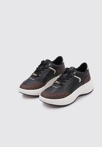 Zapatillas de cuero negro con acentos en patrón geométrico marrón, suela blanca y diseño de cordones negro. Presentan un detalle de herrajes en tono dorado.