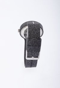 Reloj negro con motas blancas, cara redonda y herrajes plateados. La correa es texturizada, con un cierre y múltiples agujeros de ajuste.