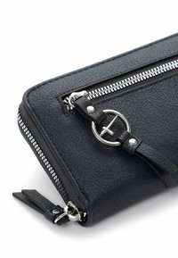 Portefeuille noir en cuir texturé avec des zips argentés, un détail en matériel circulaire et une forme rectangulaire mince. Les accents incluent un tirette en cuir.