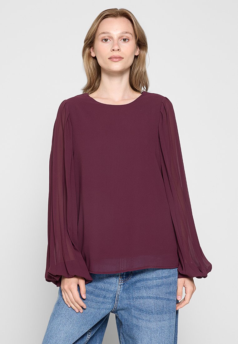 Burgunderfarbene Bluse mit langen Ärmeln, rundem Ausschnitt und plissierten Ärmeln; aus leichtem, fließendem Stoff gefertigt. Tragen Sie sie zu Jeans.