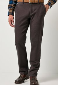 Pantaloni grigi scuri in taglio dritto, realizzati in tessuto morbido. Presentano tasche frontali e una chiusura zip, abbinati a stivali in pelle marrone.