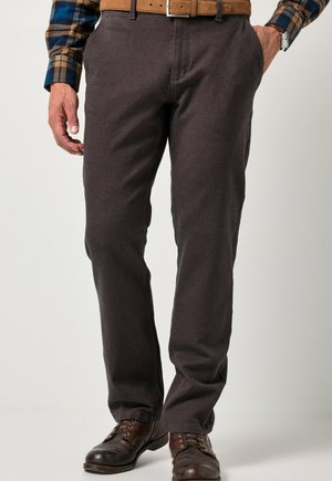Pantalones gris oscuro de corte recto, hechos de una tela suave. Cuentan con bolsillos delanteros y una bragueta con cremallera, combinados con botas de cuero marrón.