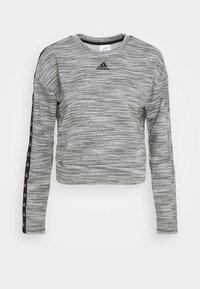 Felpa corta grigia a maniche lunghe realizzata in tessuto testurizzato. Caratterizzata dal logo adidas nero e da una striscia nera decorata lungo le maniche.
