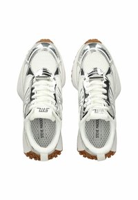 Zapatillas blancas con un acabado de cromo brillante, tejido de malla y suelas de goma texturizadas. Presenta cordones y una marca en la lengüeta.