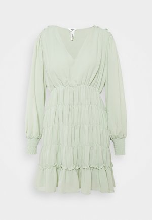 Vestito verde chiaro realizzato in morbido tessuto con scollo a V, maniche lunghe a palloncino, vita arricciata e orlo a balze sovrapposte.