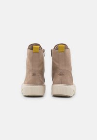 Bottines en daim marron avec semelles en caoutchouc texturé, poignées jaunes et détails de couture subtils. Fermetures éclair latérales pour une mise en œuvre facile.