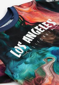 Multicolore Sweatshirt mit spiralförmigem abstraktem Muster, schwarzem Grund und dem Text "LOS ANGELES CALIFORNIA" in fetten weißen Lettern.