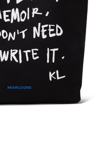 Black fabric with white handwritten-style text saying, "Don't need to write it." Blue hashtag #KARLCORE at bottom left corner.