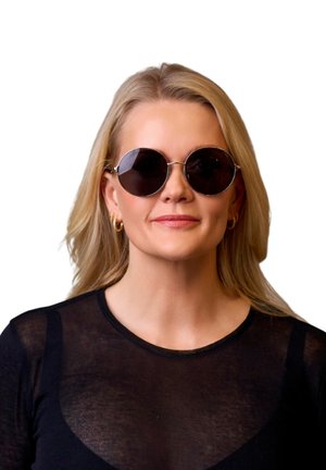 Runde, sorte solbriller med metalramme. Store linser, minimal detaljer, båret af en person med langt, blont hår og en sort top.