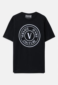 Svart bomulls T-skjorte med korte ermer, med et stort rundt hvitt logo som har teksten "VERSACE JEANS COUTURE" og et sentralt 'V'-design.