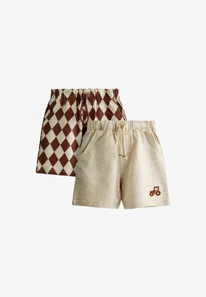 Dos pares de pantalones cortos infantiles con cintura elástica, uno beige con un pequeño tractor marrón como icono y otro con un patrón de diamantes en marrón y crema.