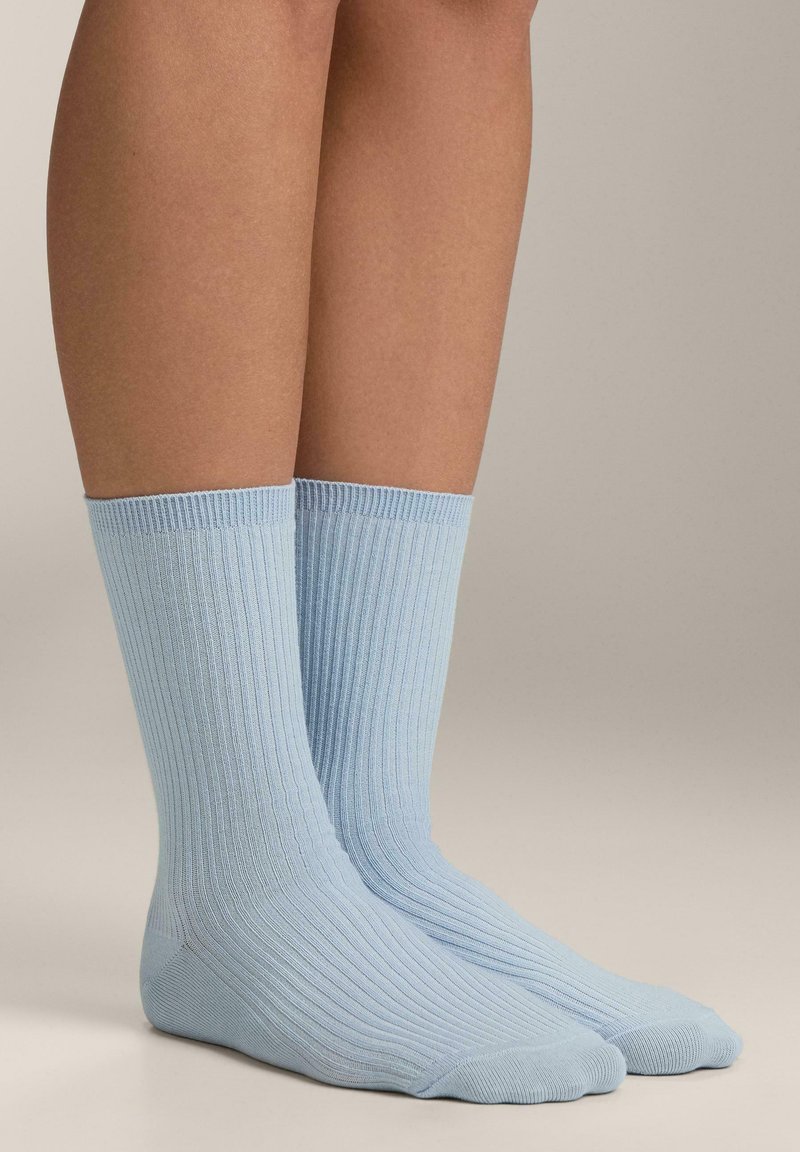 Világoskék, bordázott zokni texturált felülettel, középmagas szárú. Bordás felsőrésszel és sima varrású lábujjrészlettel.
