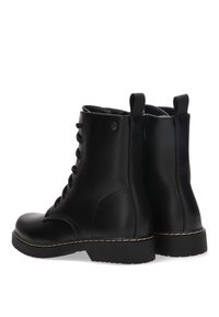 Botas de cuero negro hasta el tobillo con punta redonda, cordones en la parte delantera y un tirador en la parte posterior. Presentan una suela resistente con detalles de costura en contraste.