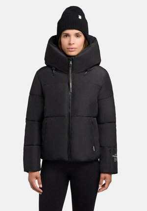 Giacca nera imbottita con colletto alto e chiusura con zip, dotata di tasche laterali e marchio discreto sul maniche. Tessuto morbido e design isolato.