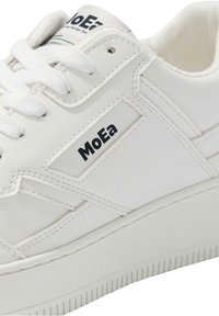 Hvite sneakers med en glatt skinnoverdel, med flate lisser, sydd detaljer og en logo-lapp. Teksturert gummisåle med riller.