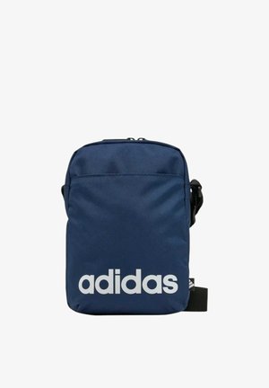 Bolso bandolera Adidas azul marino con texto del logo en blanco en el frente y correa negra ajustable contra fondo blanco.