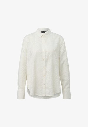 Camicia bianca a manica lunga con bottoni, con una sottile trama floreale, colletto a punta e orlo arrotondato, mostrata su uno sfondo neutro.