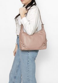 Roze leren handtas met een gestructureerd oppervlak, voorzien van zilveren hardware accentueringen, een verstelbare schouderband en decoratieve lussen aan de zijkanten.