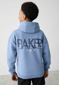 Svijetloplava dukserica s kapuljačom, mekani materijal, oversized kroj, s otisnutim logotipom "BAKER BY TED BAKER" u tamnoplavoj boji na leđima. Rebrasti manšeti i rub.
