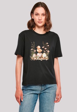 Black cotton t-shirt featuring a colorful graphic of a duck and decorated eggs with flowers and greenery, short sleeves, loose fit.
