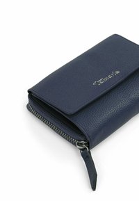 Tamsiai mėlyna odinė piniginė su tekstūruotu paviršiumi, šonuose užsegama užtrauktuku ir priekyje turi metalinį logotipą.