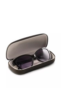 Czarne okulary przeciwsłoneczne o eleganckim designie i wyraźnym kształcie kocich oczu, umieszczone w teksturowanym czarno-beżowym etui. Soczewki są ciemne i odbijające światło.