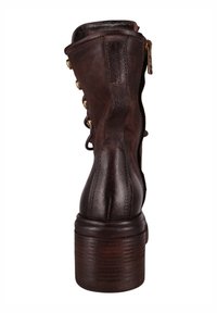 Brązowy skórzany botek za kostkę o lekko teksturowanej powierzchni, z suwakiem i złotymi guzikami po boku. Obcas złożony z drewna.