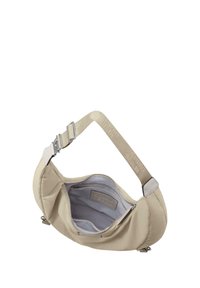 Beige stoff skulderveske med et mykt, polstret design, sølvfarge detaljer og en merket stropp. Innvendig har den et lys grått fôr og glidelåslommer.