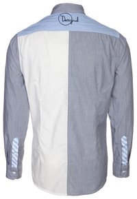 Hemdsbluse mit gespaltenem Design: linke Seite marineblau, rechte Seite weiß. Blau gestreifte Details an den Manschetten und am Kragen hinten. Markenlogo gestickt.