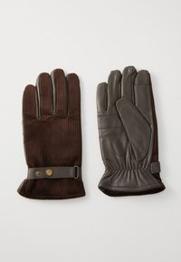 Een paar bruine handschoenen met corduroy stof bovenop en leren handpalmen, met knoopstrapjes bij de polsen, plat gelegd op een witte ondergrond.