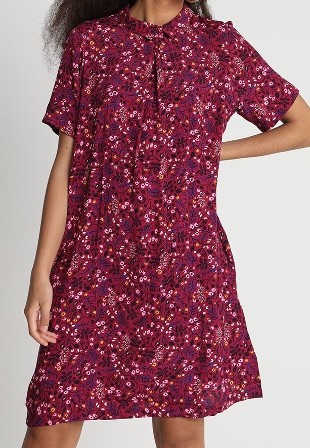 Kortærmet kjole i mørkerødt stof med blomstermønster i pink og lilla nuancer, med krave og knapdetalje ved halsen.