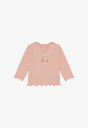 Roze shirt met lange mouwen en een afgeronde zoom. Heeft de tekst "oopsie daisy" in goud en rood, met een knoop op de schouder en een zachte textuur.