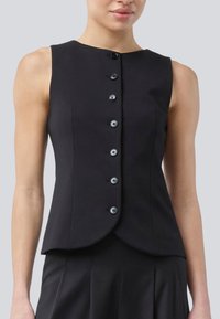 Zwarte mouwloze top met een hoge halslijn, knopen aan de voorkant en een getailleerde taille. Glad tekstuur en afgeronde zoom, met zes zwarte knopen.