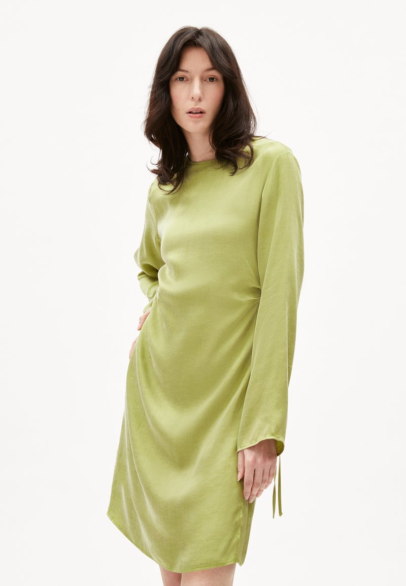 Langärmliges Kleid aus leicht grünem Stoff, mit lockerer Silhouette, rundem Ausschnitt und dezenten Seitenschlitzen am Saum.
