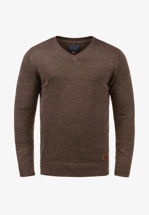 Pull brun en V fabriqué en matériau tricot doux. Présente des poignets et un ourlet côtelés, avec une petite étiquette en cuir de marque en bas à gauche.
