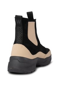 Czarno-beżowe botki za kostkę wykonane z materiału zamszowego, z akcentem w postaci plecionki na obcasie, elastycznymi bocznymi panelami oraz masywną czarną gumową podeszwą.