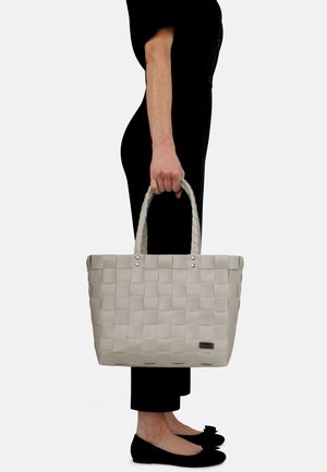 Woven graue Tragetasche mit zwei strukturierten Griffen, silbernen Hardware-Akzenten und rechteckiger Form. Die Tasche hat ein Logodetail an der Seite.