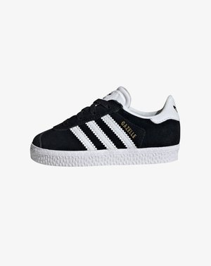 Mustat samettiset sneakerit, joissa on valkoinen kumipohja, kolme valkoista raitaa ja kultainen "Gazelle"-yksityiskohta. Klassinen muotoilu, pyöreä kärki, nauhakiinnitys edessä.