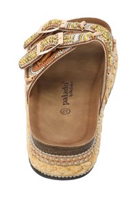 Sandale en paille tissée avec deux boucles métalliques, accents décoratifs en perles, doublure beige et semelle à motifs. Design léger avec un talon plat.