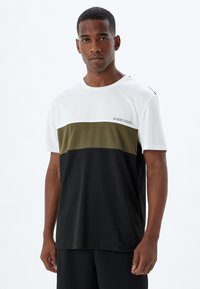 Camiseta atlética para hombres con un dise�ño en bloques de color blanco, verde oliva y negro. Fabricada en tela ligera, con un cuello redondo y detalle impreso.