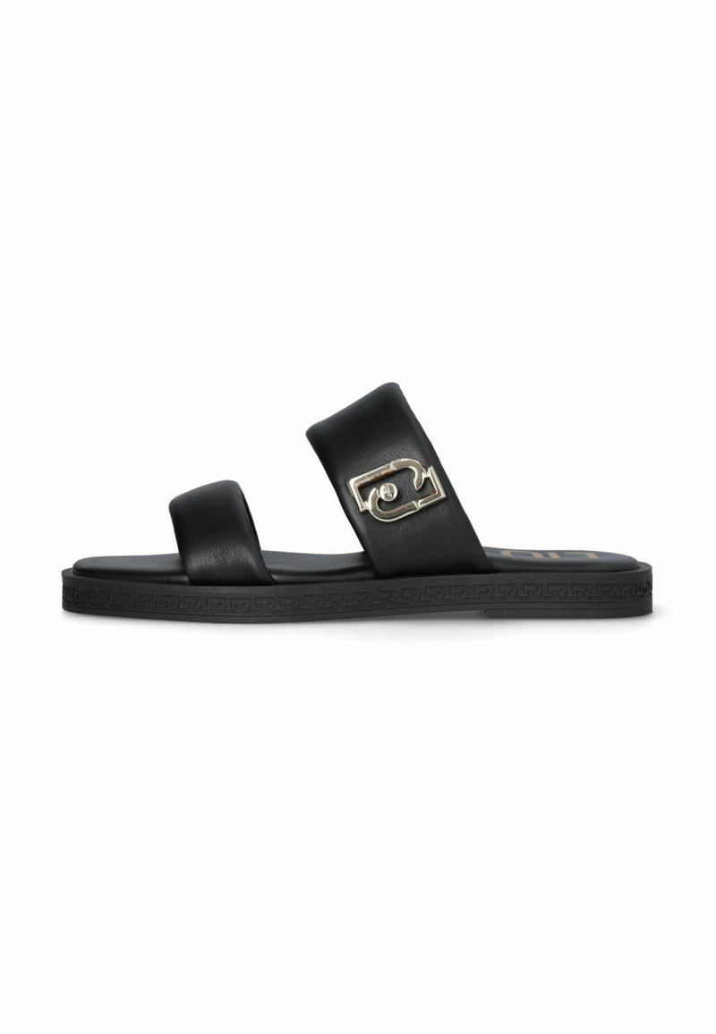 Sandales en cuir noir avec deux larges brides, comportant un accent métallique, et une semelle en caoutchouc plate avec des motifs décoratifs.