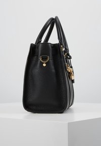 Černá kožená kabelka s texturou kůry, zlatými kovovými doplňky a dvojitými uchy. Vyznačuje se elegantním, strukturovaným tvarem s bezpečným zavíráním.