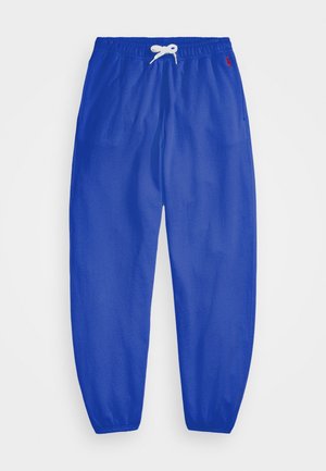 Pantalon de survêtement bleu avec taille élastique et cordon blanc, avec un petit logo rouge sur la partie supérieure gauche et des poignets élastiques aux chevilles.